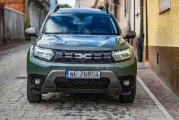 Zielony Dacia Duster na brukowanej uliczce. Sprawdź, jakie jest dacia duster spalanie i wybierz się na przygodę.