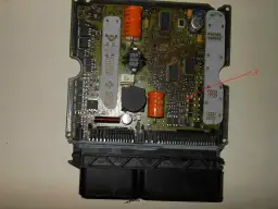 Czerwona strzałka wskazuje miejsce na płycie głównej, gdzie może wystąpić zwarcie do plusa, co oznacza uszkodzenie układu.