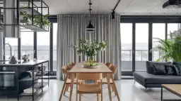 Nowoczesna lampa do jadalni nad drewniany stół z bukietem kwiatów i zielonymi jabłkami.