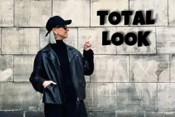 Kobieta w czarnej ramonesce, golfie i czapce prezentuje total look. Stylowe czarne stylizacje to jej znak rozpoznawczy.