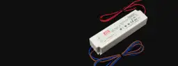 Biały zasilacz impulsowy Mean Well z czerwonymi i czarnymi przewodami. Idealny wybór, jeśli zastanawiasz się, jaki zasilacz do LED będzie najlepszy.