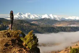 Kobieta na skale z widokiem na góry i morze mgły. To piękne lesnicke sedlo, idealne na wędrówkę.