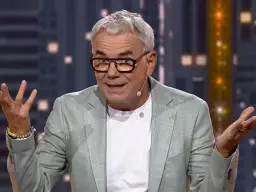 Kto prowadził "Jaka to melodia"? To Hubert Urbański, znany prezenter, w jasnej marynarce i okularach, z gestykulacją.