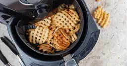 Frytki kratkowane w koszu frytkownicy beztłuszczowej.