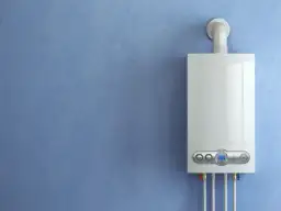 Nowoczesny piec gazowy kondensacyjny na niebieskiej ścianie. Wyświetlacz pokazuje 19.6°C. Idealna temperatura do ustawienia na piecu gazowym kondensacyjnym.