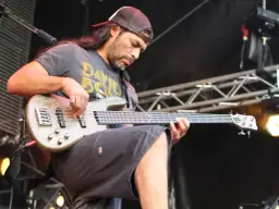 Robert Trujillo z zespołu gra na basie, skupiony na występie.