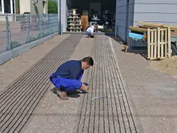 Instalacja systemu ogrzewania podjazdu. Pracownicy układają kable grzewcze. Dowiedz się, ile kosztuje podgrzewany podjazd.