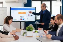Zespół omawia wyniki na ekranie, jak wstawić link do prezentacji powerpoint.