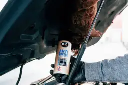 Rękawiczka z preparatem K2 Anti Marten pod maską samochodu. Dowiedz się, jak podłączyć odstraszacz kun w samochodzie, by chronić gumowe i plastikowe części.
