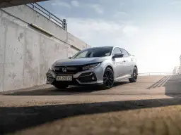 Srebrna Honda Civic 7 na tle betonowej ściany i nieba.