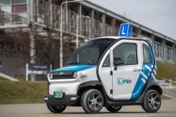 Mały, biało-niebieski pojazd samochodowy inny niż typowe auto, z literą "L" na dachu, idealny do nauki jazdy.
