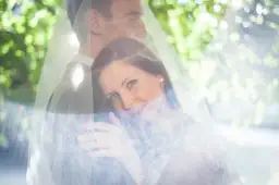 Para młoda pod welonem, z welonu przebija światło, tworząc efekt flary.