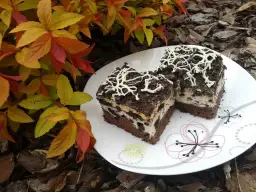 Dwa kawałki pysznego, pieczonego sernika Oreo z kremową masą i kawałkami ciastek, udekorowane białą czekoladą.