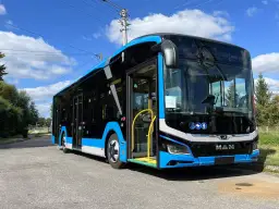 Nowy, niebiesko-czarny autobus MAN, gotowy do kursu Zamość-Kraków, stoi na ulicy.