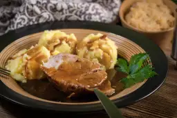 Soczysta karkówka w sosie sojowym, podana z purée ziemniaczanym i surówką. Pyszny obiad gotowy do spożycia.