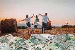 Rodzina biegnie przez pole z sianem, na pierwszym planie polskie banknoty 100 zł.