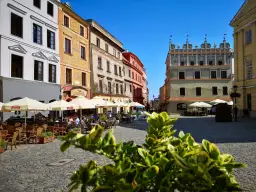 Słoneczny dzień na lublin stare miasto. Kolorowe kamienice, kawiarniane ogródki i brukowany plac tworzą urokliwą atmosferę.
