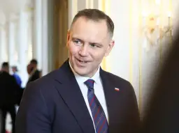 Prezydent Andrzej Duda w garniturze, z flagą Polski na klapie. Zastanawiasz się, ile zarabia prezydent Duda?
