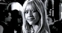 Jessica Alba w roli Nancy Callahan z Sin City, zmysłowo się uśmiecha.