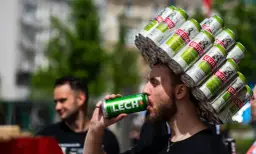 Mężczyzna z koroną z puszek piwa Kasztelan pije Lecha. Zastanawia się, ile bimbru można przewieźć do Niemiec.