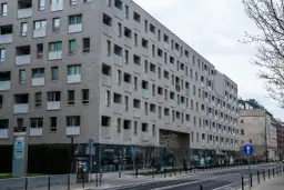 Nowoczesny budynek mieszkalny z balkonami. Zastanawiasz się, jak sprawdzić, czy mieszkanie jest zadłużone? Warto sprawdzić księgę wieczystą.