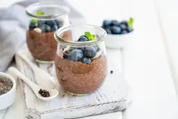 Czekoladowy pudding chia z jagodami i miętą w słoiku.