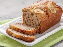 Pyszny chleb bananowy z orzechami pekan i plasterkami banana na wierzchu. Idealny przepis na to, jak zrobić chleb bananowy.