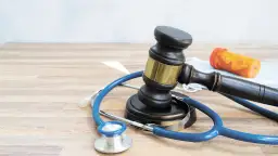 Młotek sędziowski, stetoskop i buteleczka z lekami symbolizują testament życia i jego kruchość.