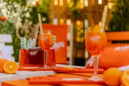 Dwa kieliszki do aperolu, ozdobione pomarańczami i słomkami, gotowe do orzeźwiającej chwili.
