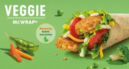 Veggie McWrap z kotletem warzywnym, sałatą, pomidorem, serem i sosem. Widać też groszek, marchewkę i brokuł.