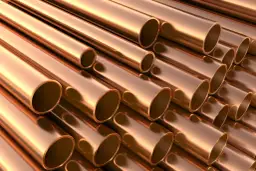 Stosowanie brązu w instalacjach wodnych i grzewczych. Metaliczne rury miedziane ułożone równolegle, tworzące teksturę.