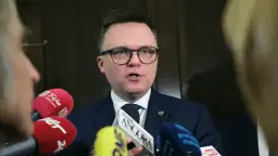 Polityk w okularach przemawia do mikrofonów. Liderzy partii politycznych często udzielają wywiadów mediom.