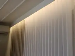 Eleganckie zasłony z podświetleniem ściany od góry tworzą przytulną atmosferę.