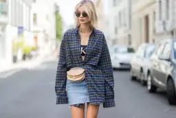 Modna stylizacja: jak nosić koszulę w kratę damską. Luźna koszula, jeansowa spódniczka i torebka na biodro.