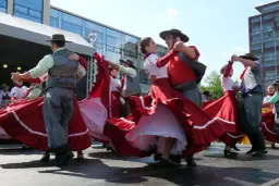Tancerze w tradycyjnych strojach, z jakiego kraju pochodzi polka? Wirujące czerwone spódnice i męskie kamizelki.