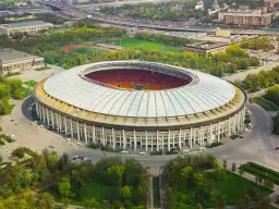 Stadion Łużniki w Moskwie, gdzie grają moskiewskie kluby piłkarskie, otoczony zielenią i drogami.