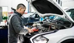 Mechanik sprawdza auto, by dowiedzieć się, ile trwa badanie techniczne pojazdu.
