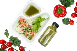 Pudełko z sałatką, butelka zielonego napoju i warzywa. Zastanawiasz się, ile kosztuje catering dietetyczny na miesiąc?