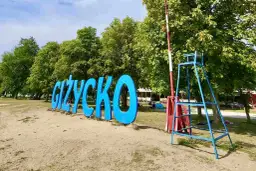 Napis GIŻYCKO na plaży, obok ratownicza wieża. Idealne miejsce na wakacje, mnóstwo giżycko atrakcje dla dzieci.