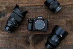 Sony Alpha 7 III, lustrzanka czy bezlusterkowiec? Obok aparatu leżą trzy obiektywy, gotowe do akcji.