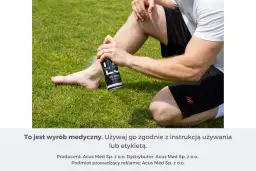 Mężczyzna stosuje spray chłodzący przeciwbólowy na nogę siedząc na trawie.