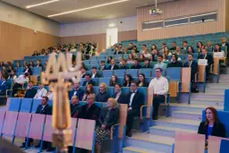 Uroczystość wręczenia dyplomów. Młodzi ludzie zastanawiają się, co po studiach medycznych, siedząc w auli.