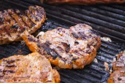 Karkówka grillowana na ruszcie, z widocznymi śladami przypieczenia i sokami.