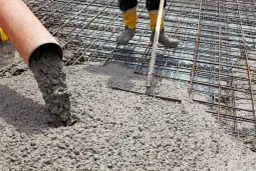 Wylewanie betonu na zbrojenie fundamentów.
