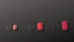 Trzy zestawy haczyków wędkarskich z przynętami w różnych rozmiarach na ciemnym tle.