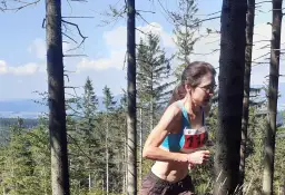 Anna Celińska biegnie przez las, numer 118 na piersi.