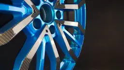 Niebieska felga z elementami imitującymi włókno węglowe, wykonana metodą hydrografiki.
