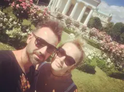 Mateusz Ziółko z żoną w słoneczny dzień wśród kwitnących róż.