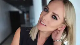 Uśmiechnięta wokalistka, która mogłaby zaśpiewać w "Jaka to melodia?". Blond włosy, niebieskie oczy i czarna marynarka.