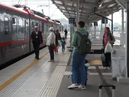 Ludzie na peronie czekają na pociąg. Zastanawiasz się, ile zarabia kierowca pociągu?